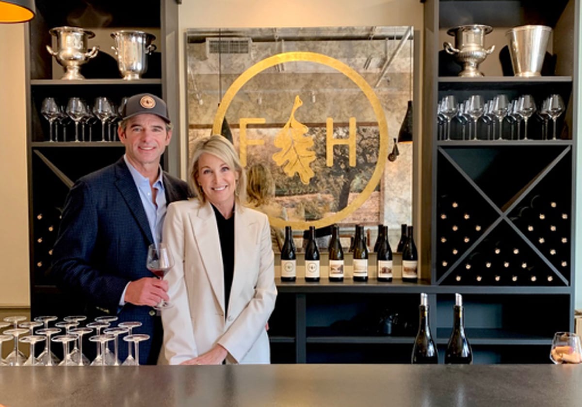 Folded Hills Montecito Tasting Room Bar with owners Andrew and Kim Busch standing next to wine and wine glasses